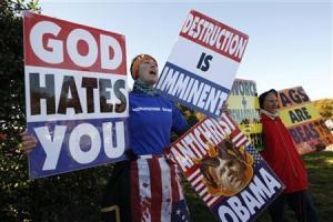 Members of the Westboro Baptist Church hold anti-gay signs at Arlington National Cemetery in Virginia on Veterans Day, November 11, 2010. The Supreme Court ruled on Wednesday that a church has the legal right to stage anti-gay protests at military funerals to promote its claim that God is angry at America for its tolerance of homosexuality. REUTERS/Kevin Lamarque